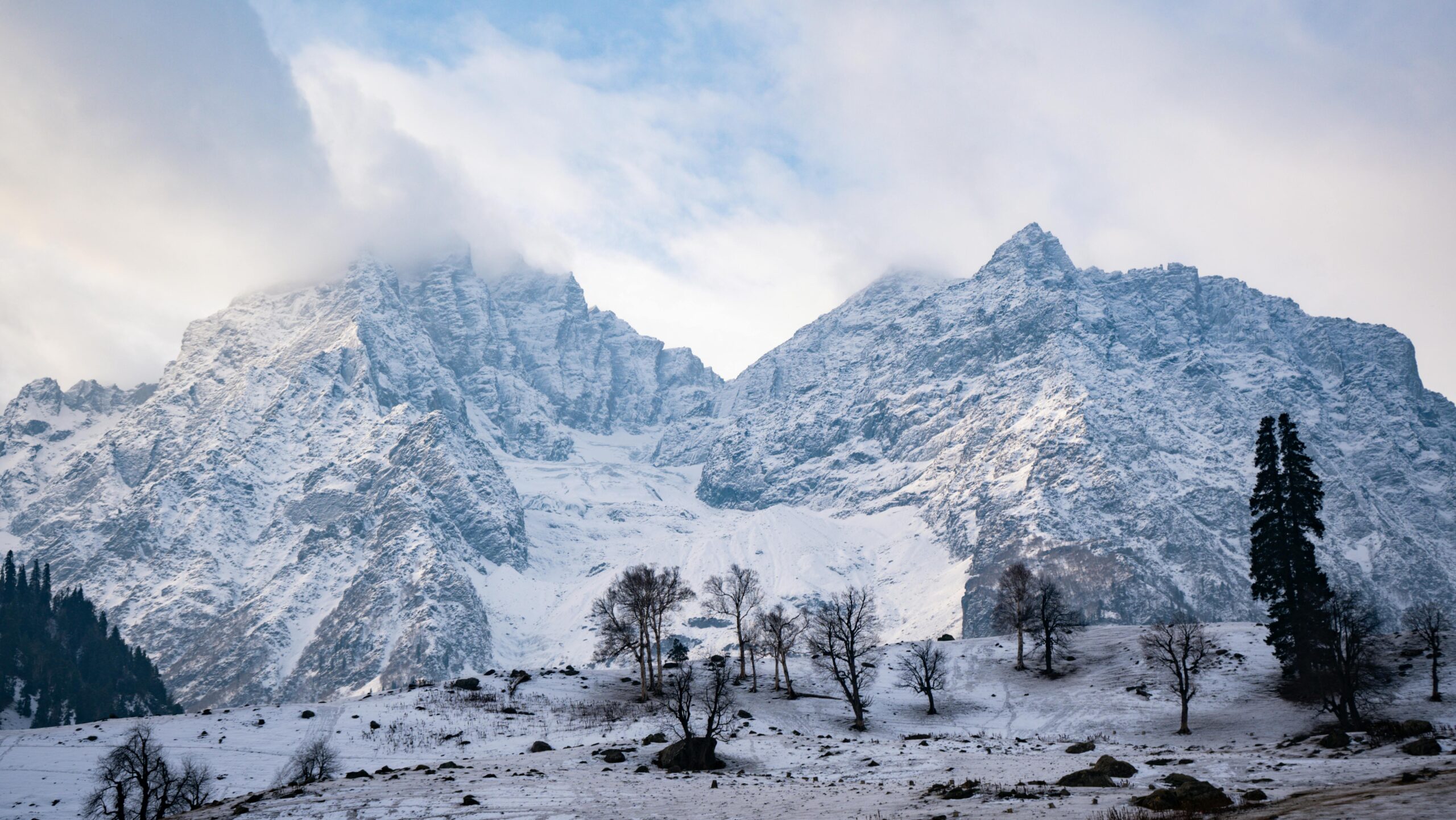Kashmir Breathtaking view of snow-covered mountains and trees in Sonamarg, Kashmir, during winter.