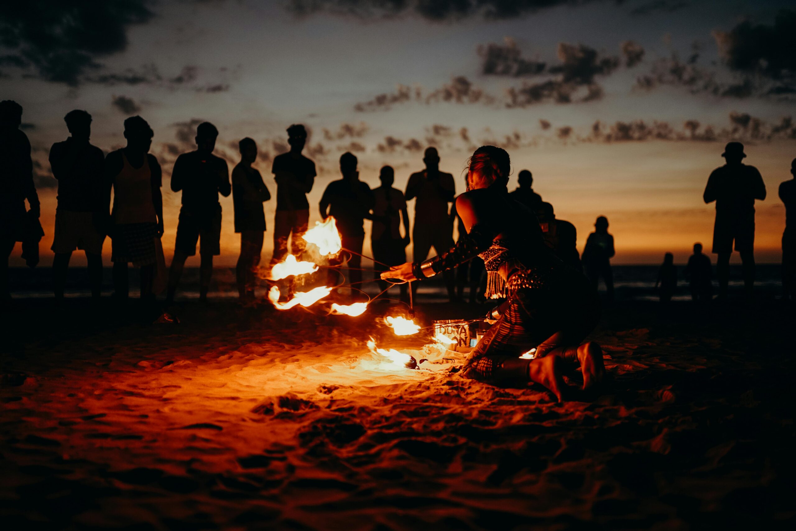 Goa A mesmerizing fire performance on a beach at sunset with a captivated crowd in Goa.